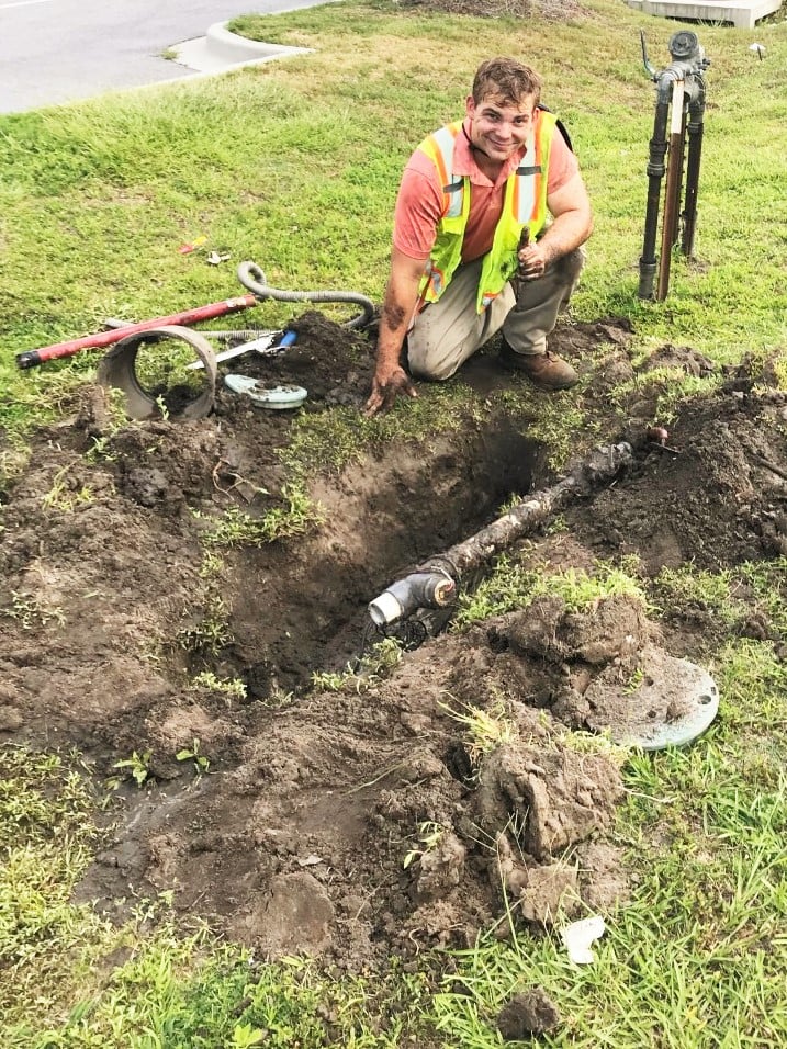 irrigation crew member repairs broken irrigation system