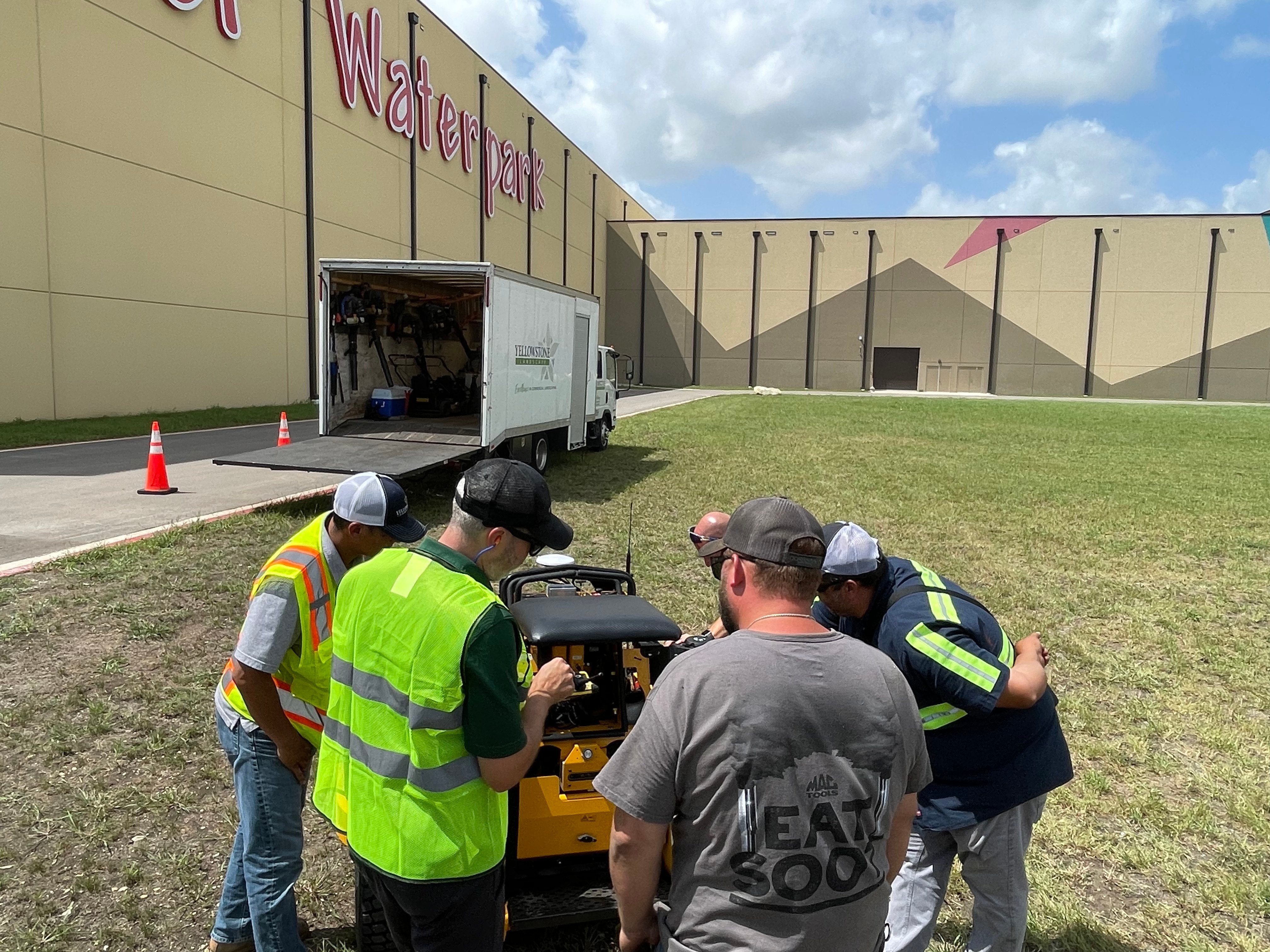 Landscape crew learning how to use an electric mower