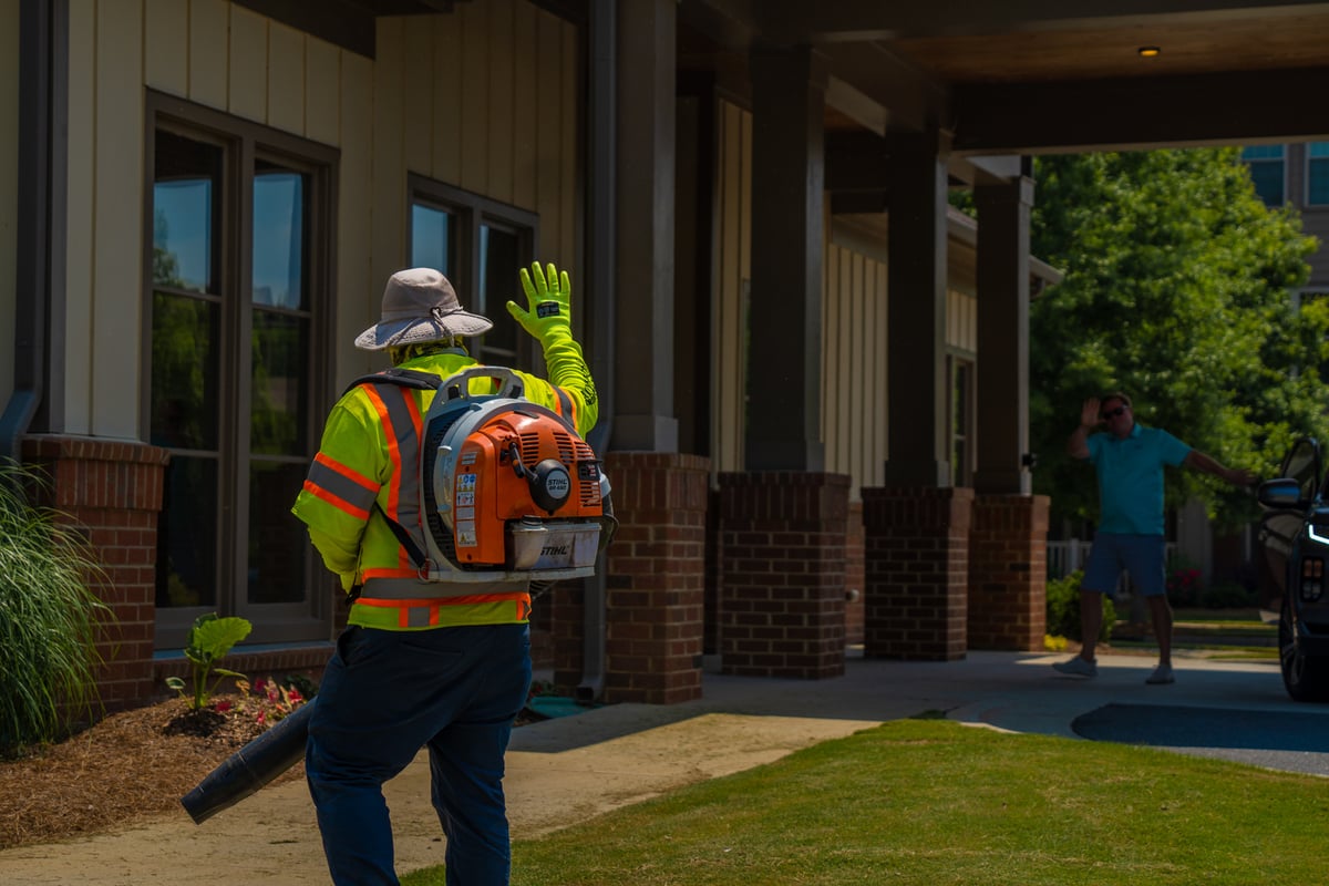 commercial landscape professional blowing leaves