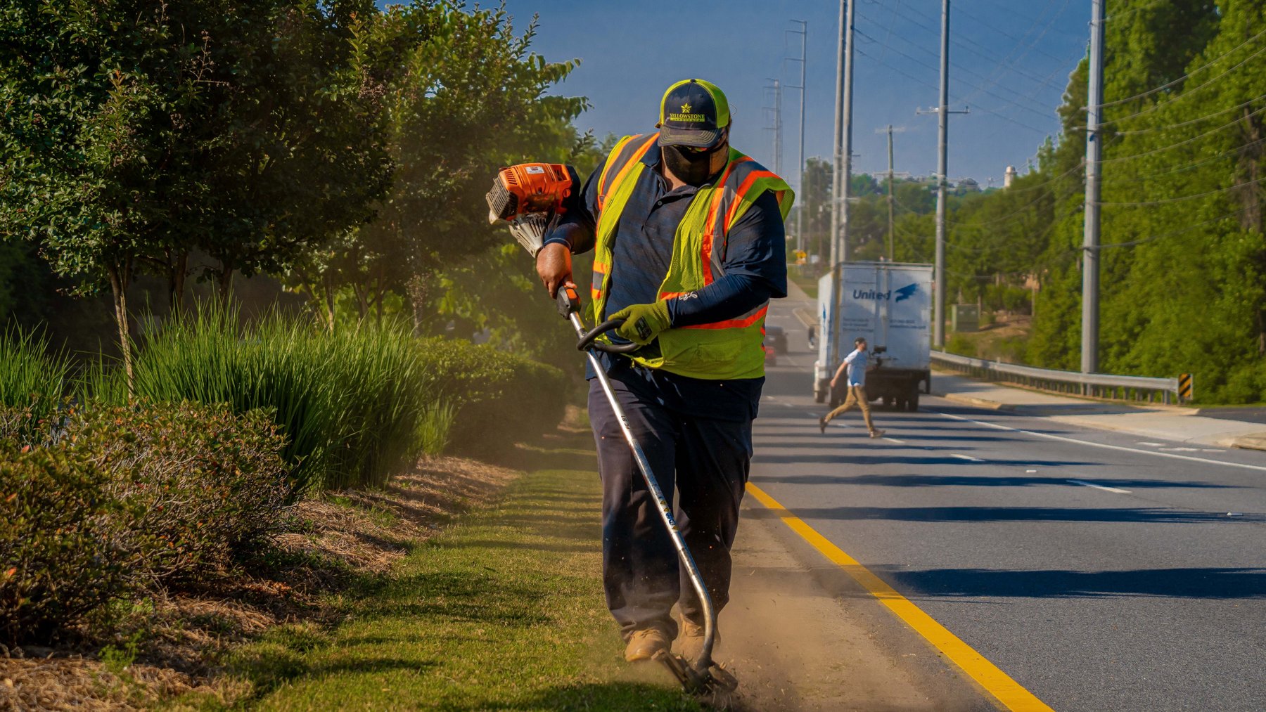 Commercial landscaping crew edging along a roadside