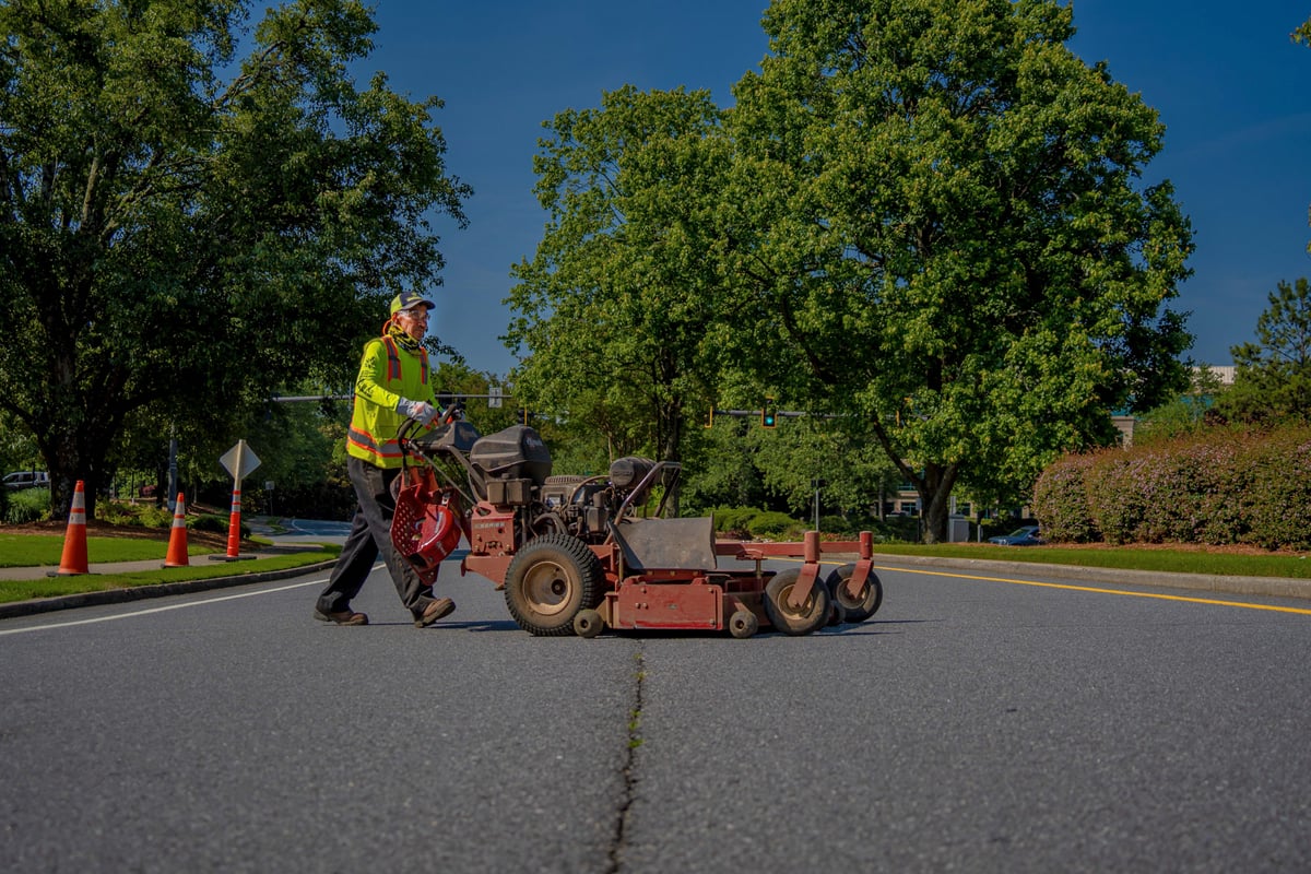 Commercial landscaping crew member with lawn mower