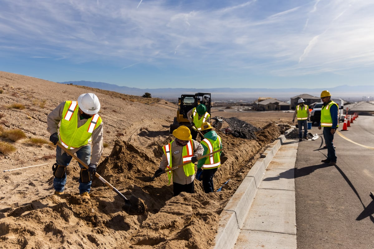 Crew digging along road for irrigation