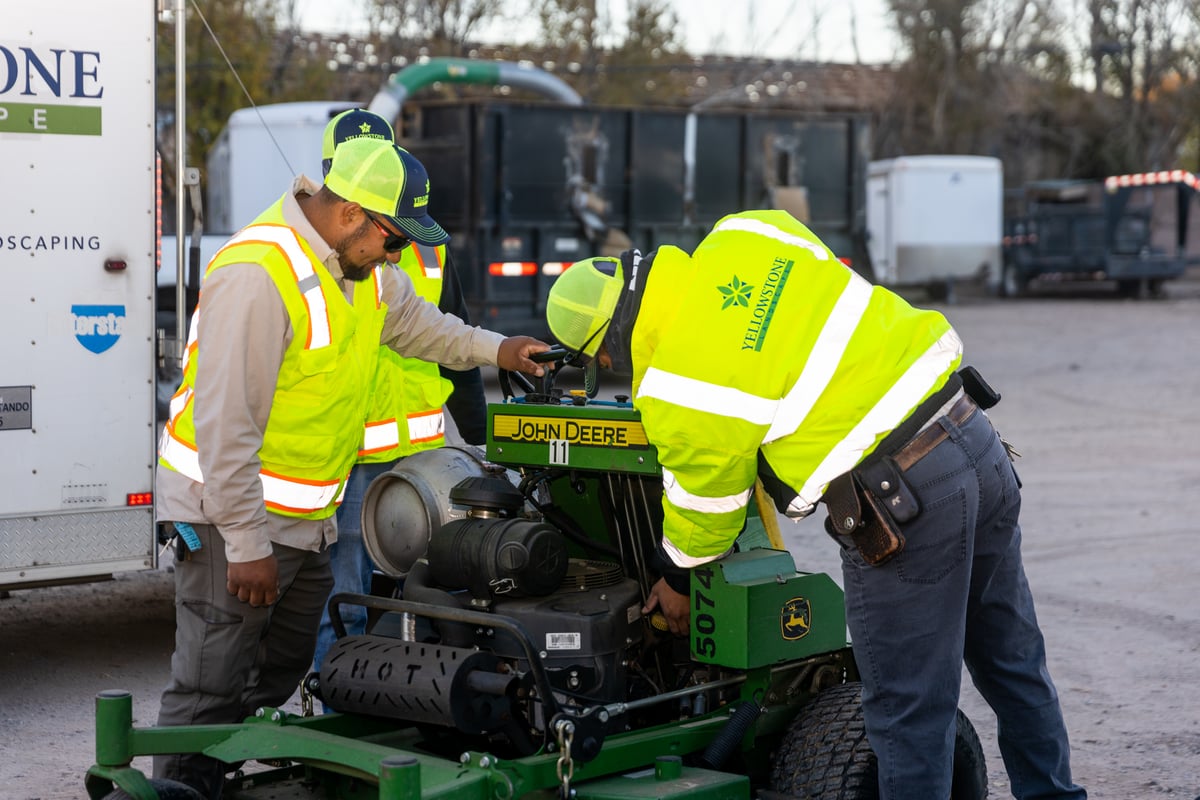 landscape maintenance team inspects mower