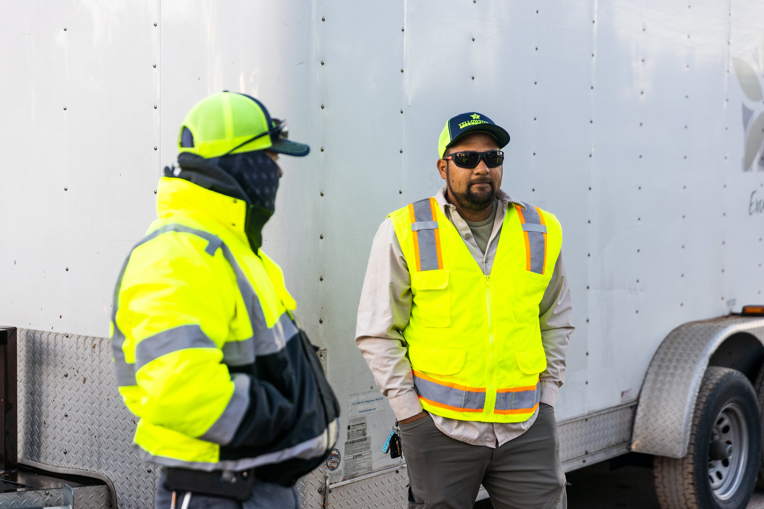 Crew talking by equipment trailer