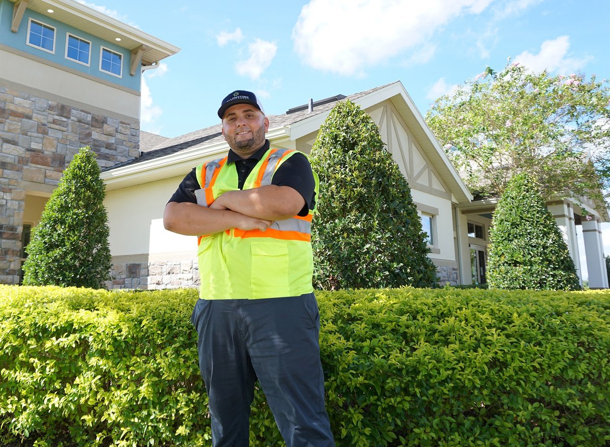 yellowstone crew leader stands in front of bushes at home