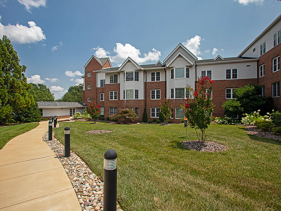 walkway at senior living community with well maintained landscape