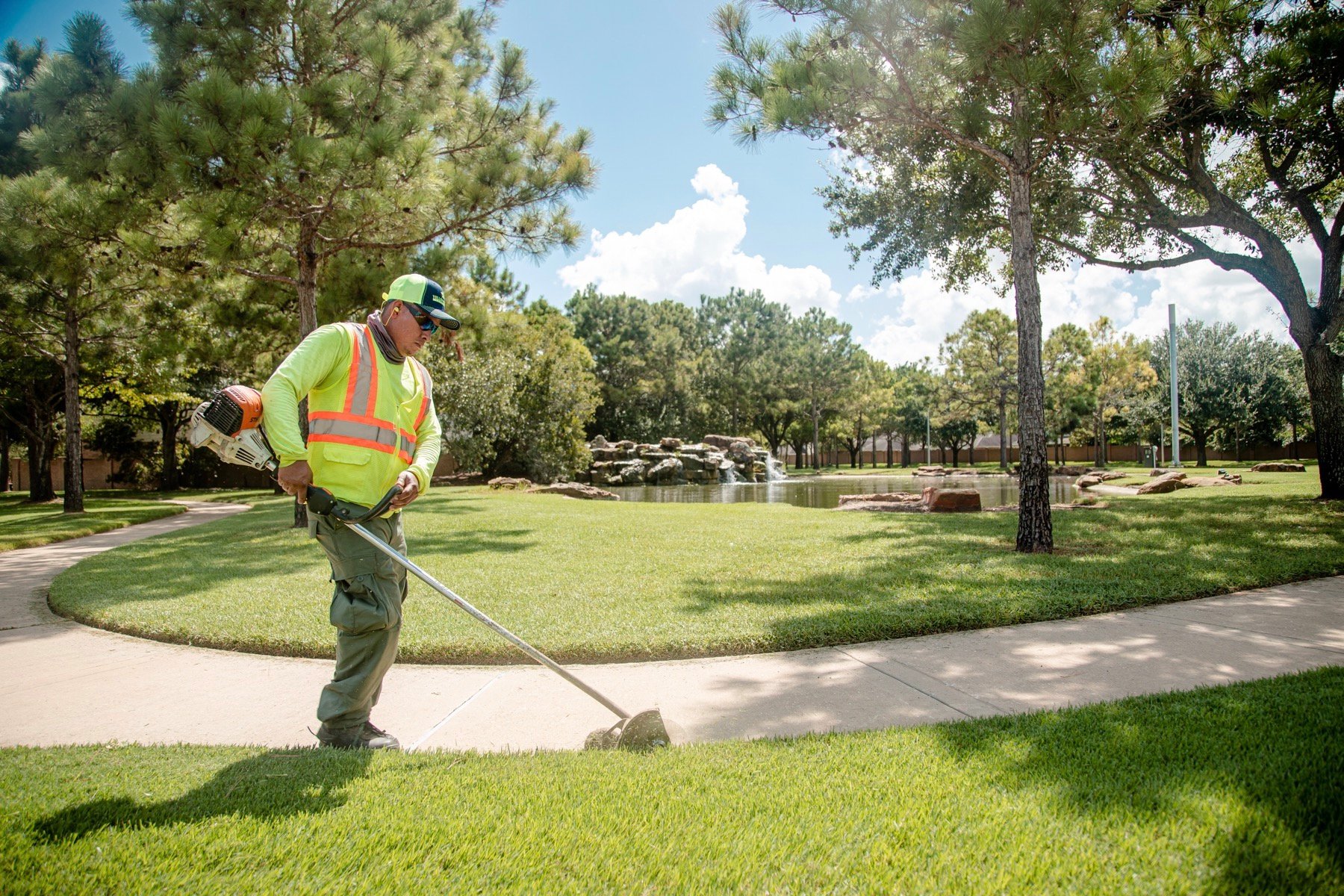 Crew member trimming HOA pathway