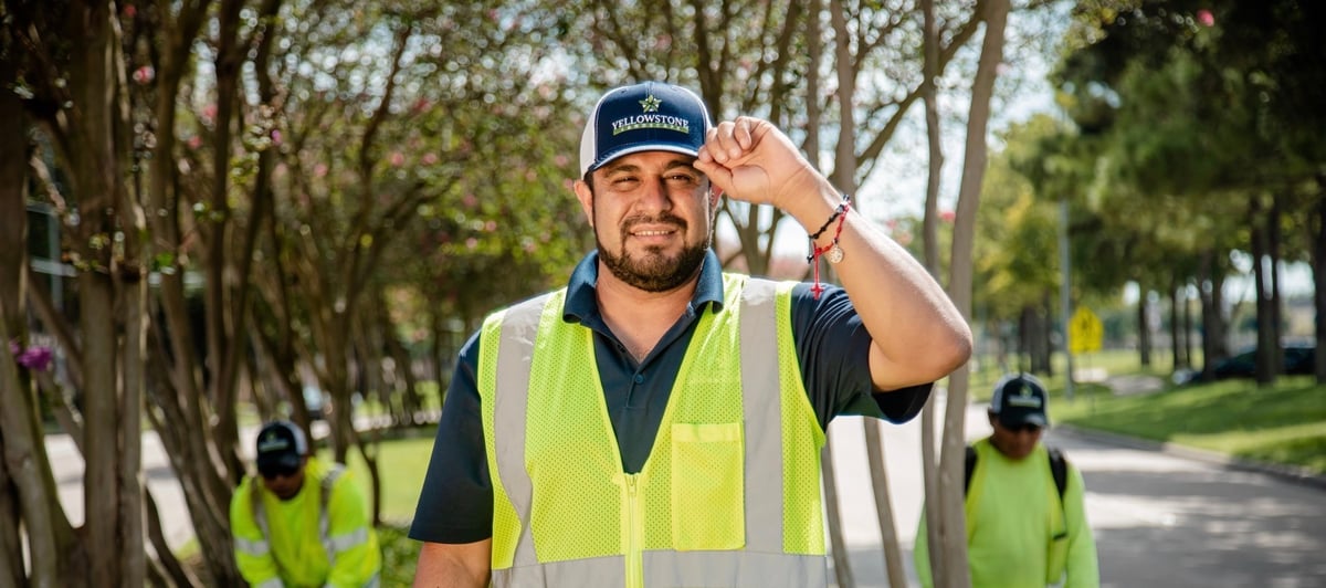 team member smiling with crew working in back