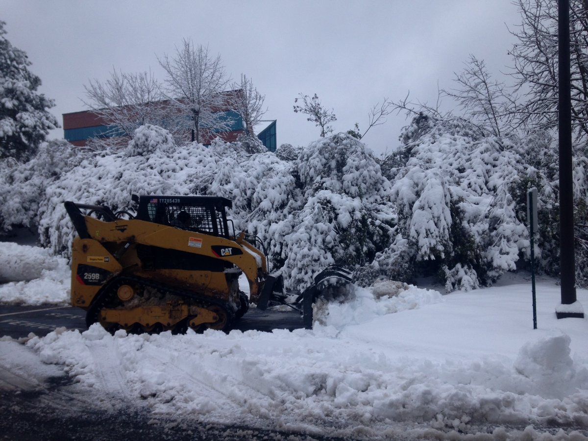 CAT skid steer pushes snow