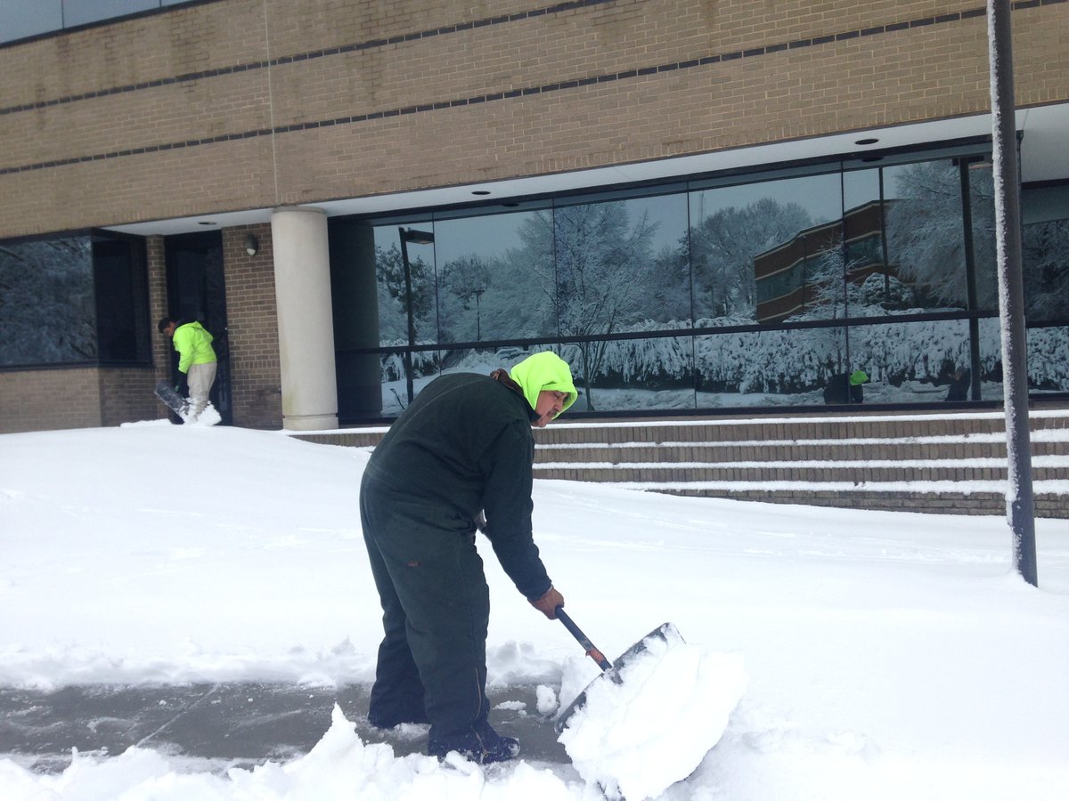landscape professionals shovel snow at commercial property