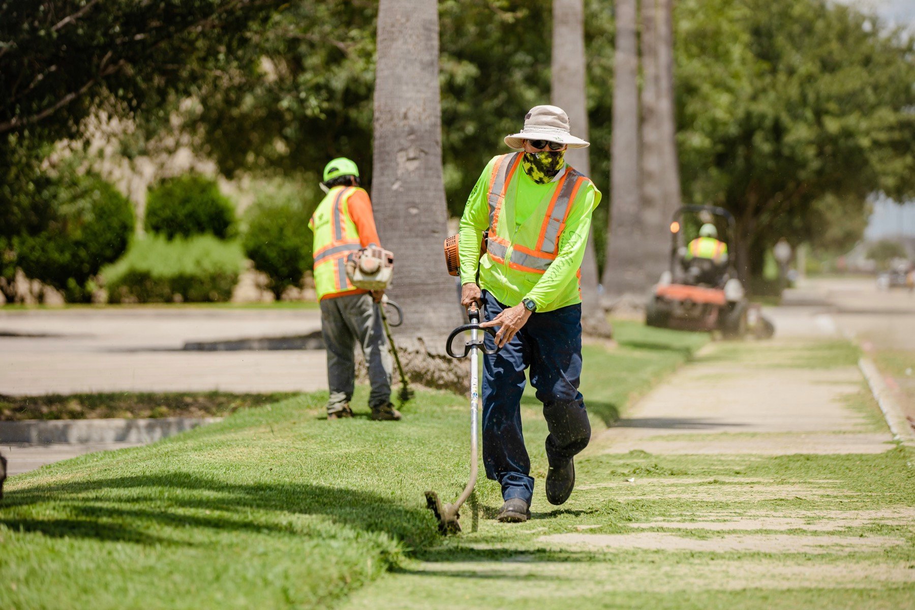 commercial lawn care team edging a sidewalk