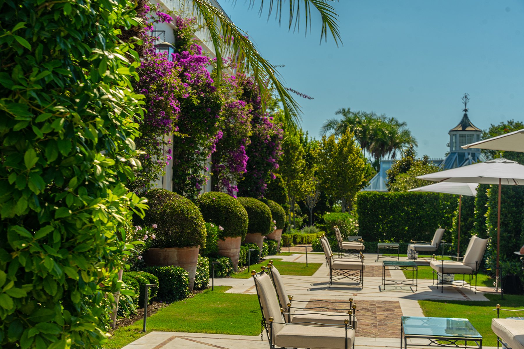 Bougainvillea-lined columns framing a private garden seating area