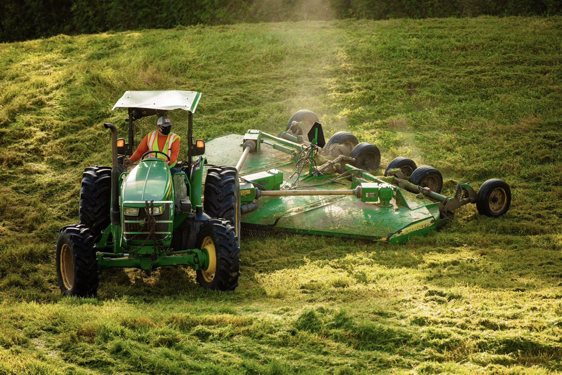 tractor mowing large acreage with attachment