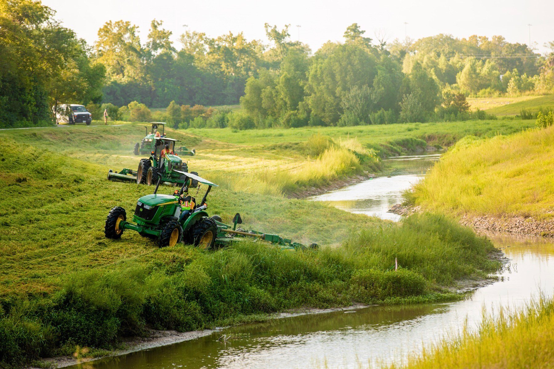 tractors mowing in a flood control area